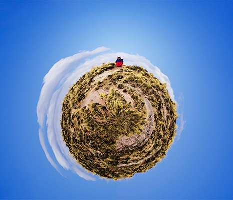 360 image of grasses, blue sky, clouds and a person